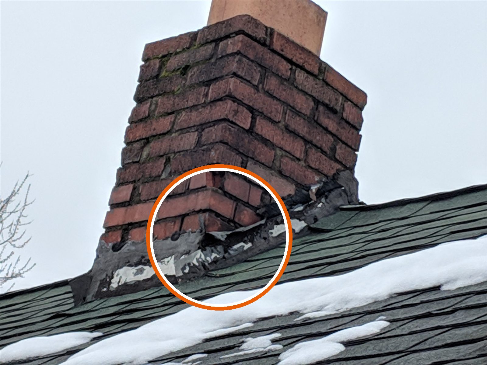 Chimney flashing patched with roofing tar