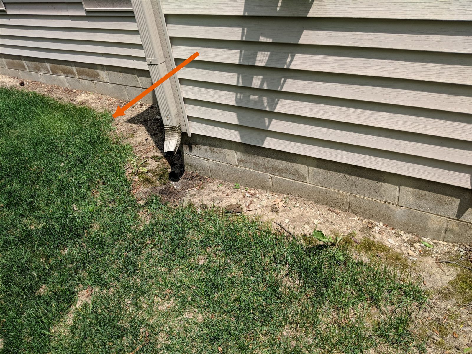 Downspout dumps water at the foundation