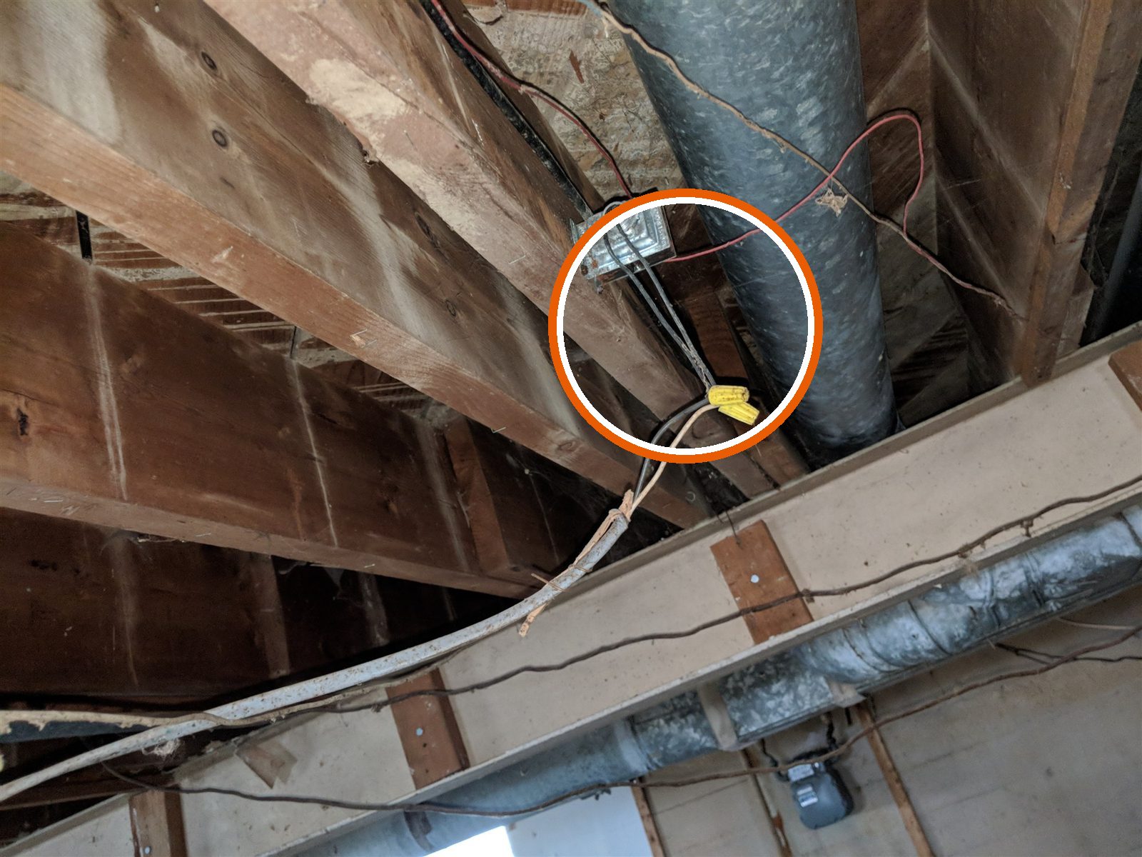Open splices hanging below an uncovered junction box