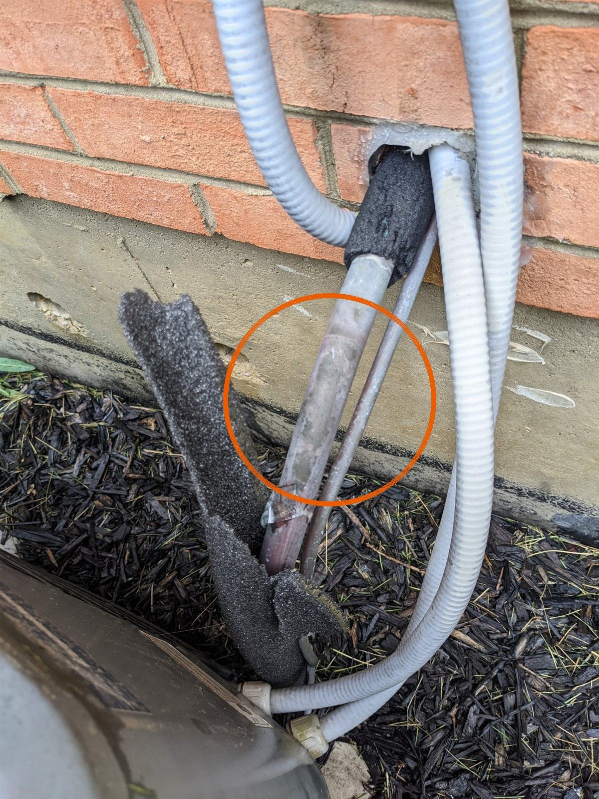 Refrigerant line insulation torn off at the wall